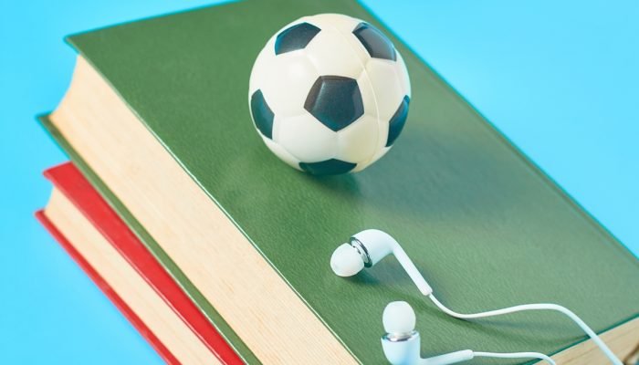 Fones de ouvido brancos, livros antigos, bola de futebol de brinquedo e b — Foto